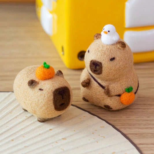 Finished Citrus Capybara felt toy with orange.