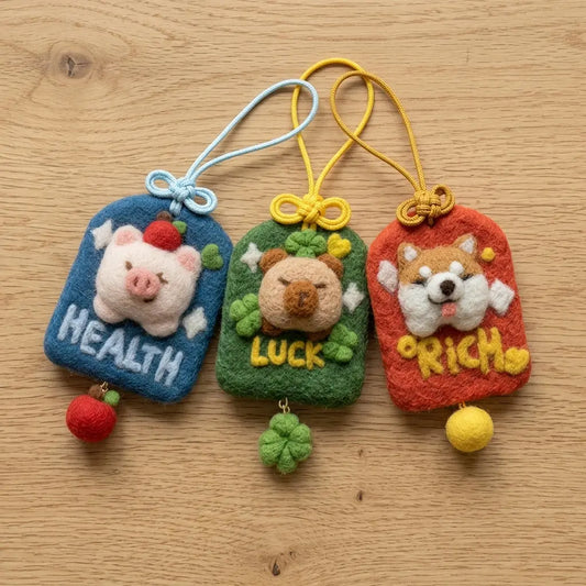 Three handmade needle felted lucky charms in red, blue and green with tassels and beads