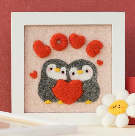 Finished Penguin Love felt frame with two penguins and heart.