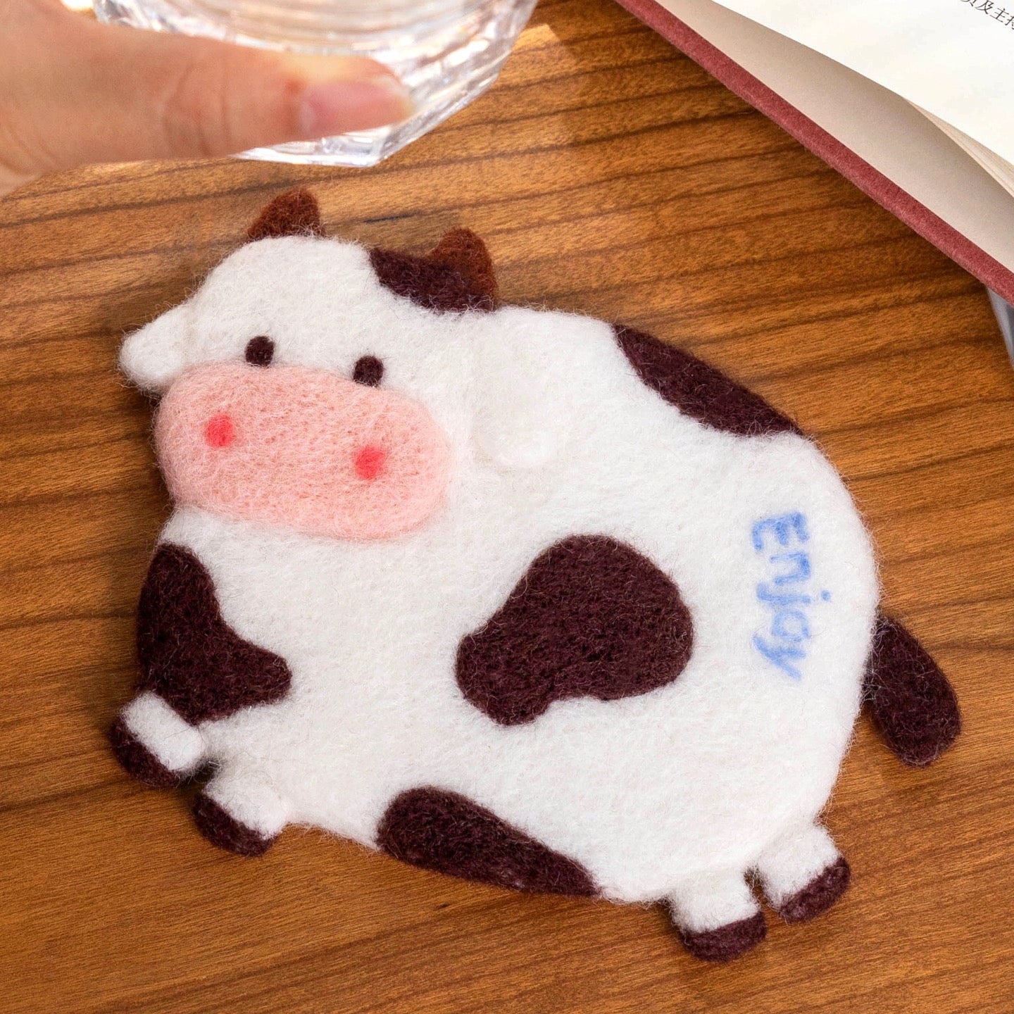 Finished Enjoy Cow felt coaster with ‘Enjoy’ text.”