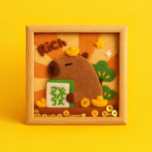 Finished Fortune Capybara wool felt frame with gold coins, made from the Joypok beginner needle felting kit