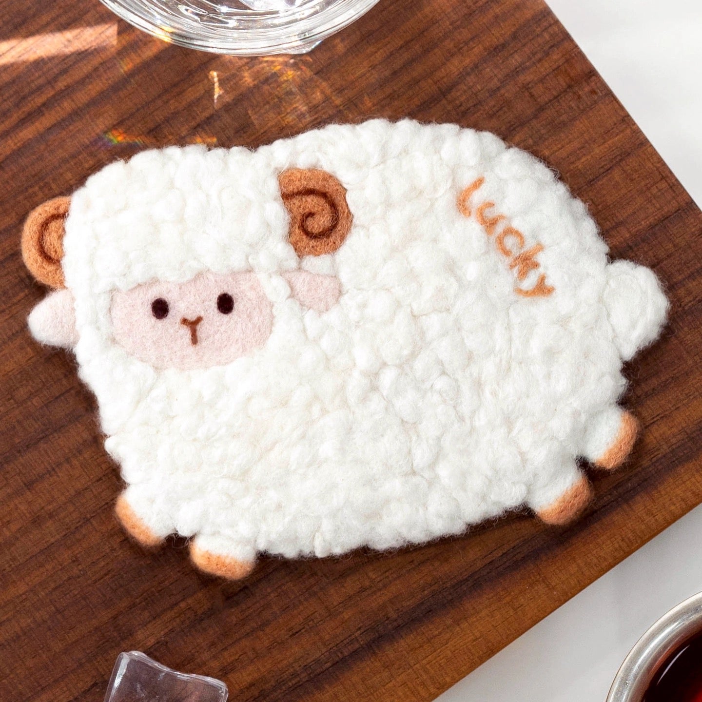 Finished Lucky Sheep felt coaster with curly wool and ‘Lucky’ text.