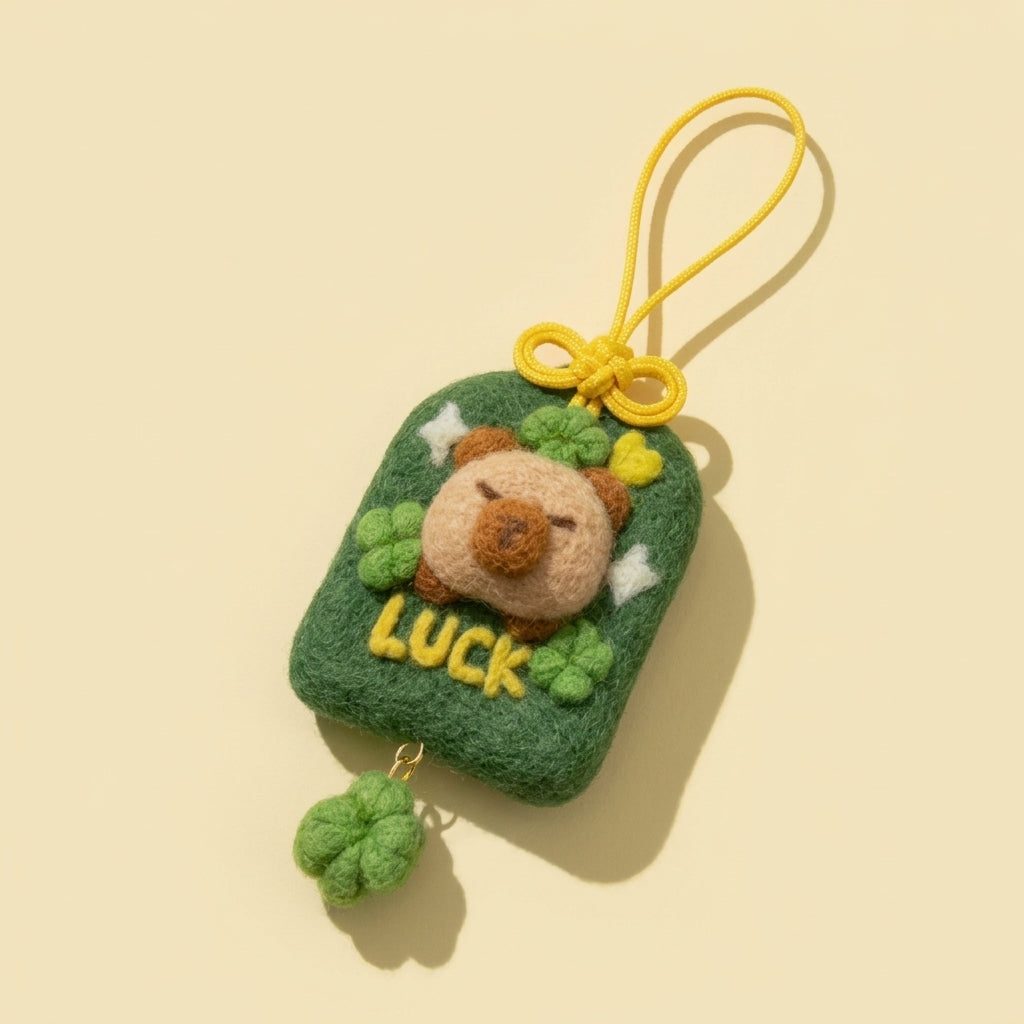 Finished Luckybara good luck wool felt charm in green with a capybara and clovers, made from the Joypok beginner needle felting kit