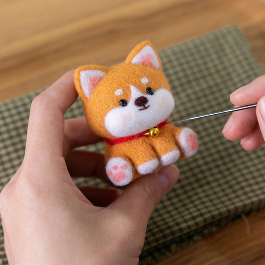 Finished Lucky Shiba felt dog with orange coat and tiny bell.